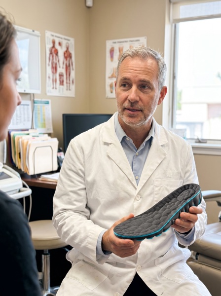 Dr. Marcus Lehmann, orthopedic specialist, holding ExtraCM insole